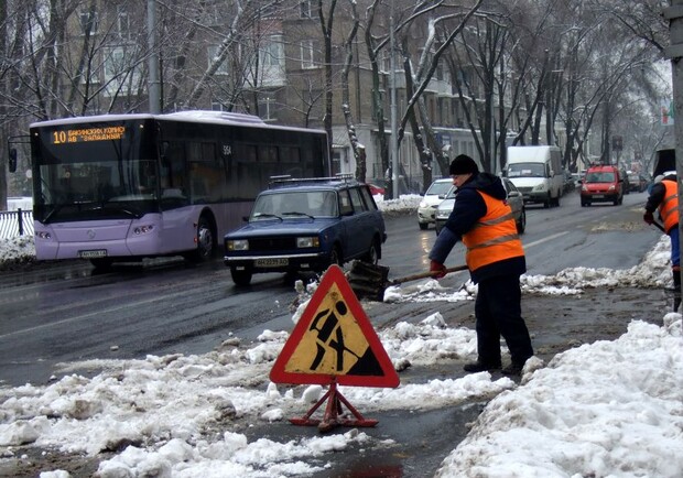 Донецкие коммунальщики бросают снег под колеса авто. Фото: 62.ua